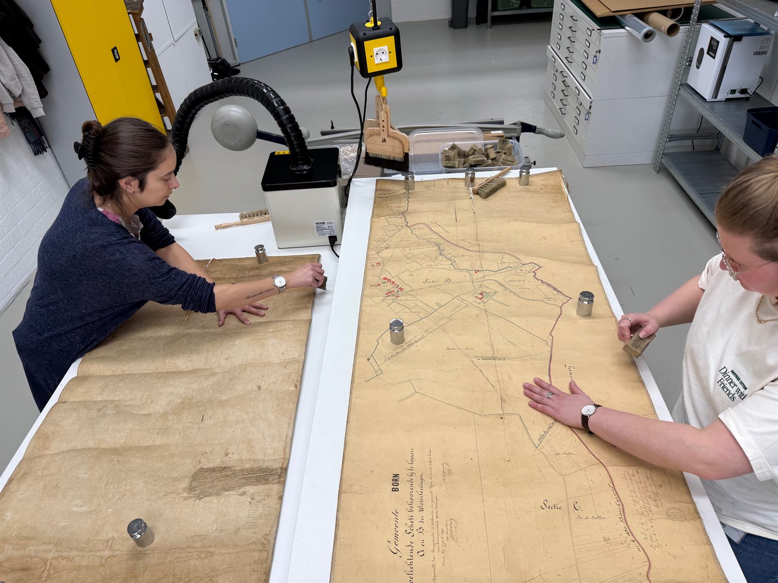 Restauratiehandeling aan kwetsbaar archiefmateriaal in het atelier